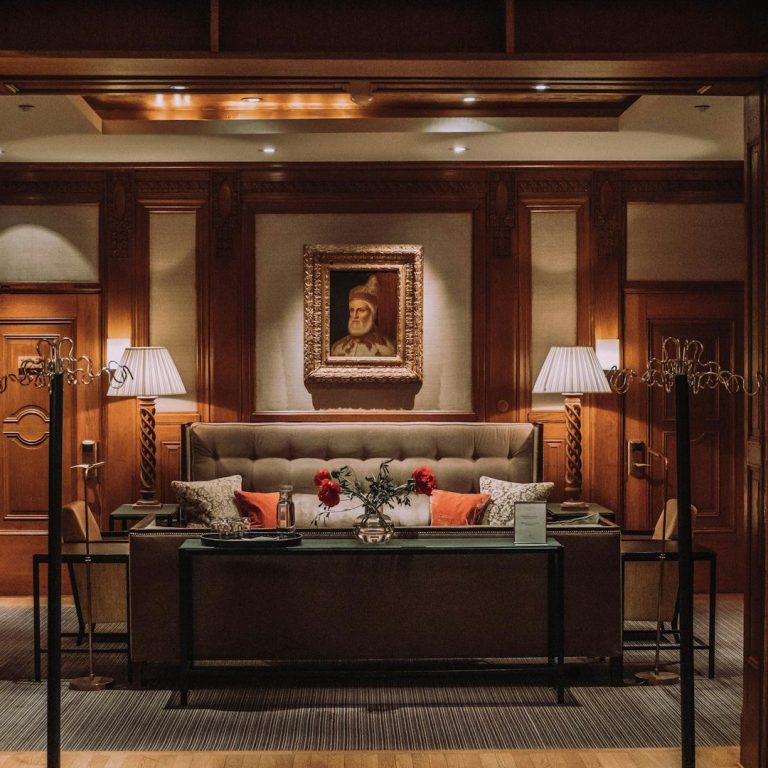 Elegantes Wohnzimmer mit einer sofaähnlichen Sitzgelegenheit und stilvollen Lampen.